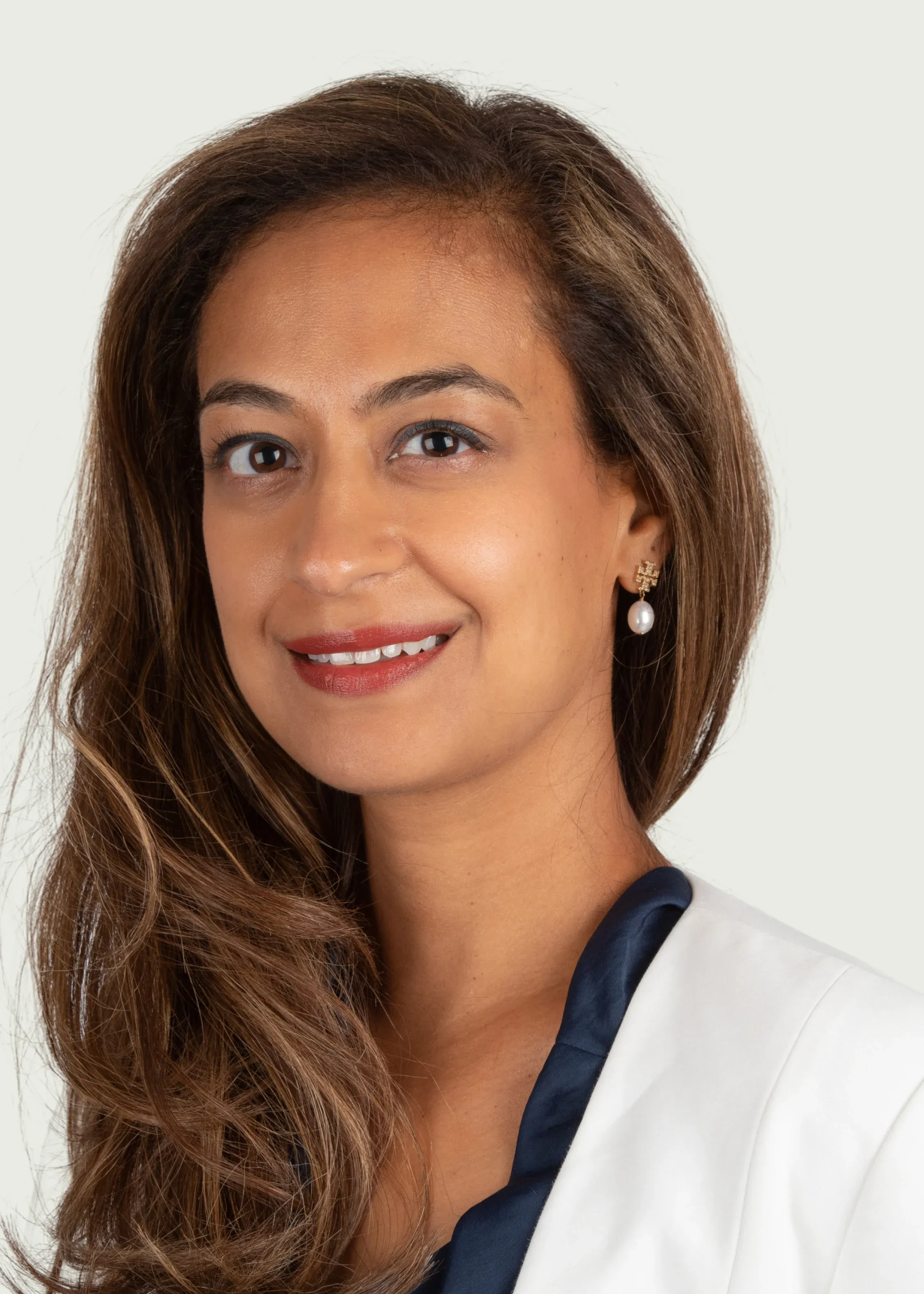 Professional headshot of female doctor smiling in white coat.