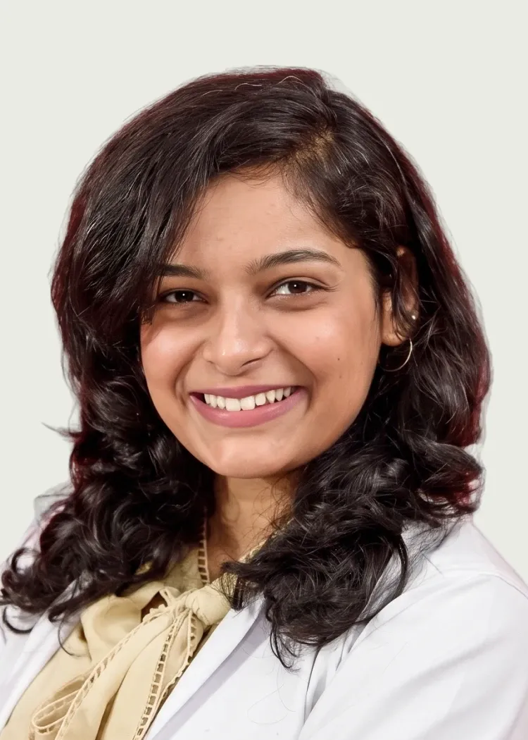 Professional headshot of smiling female doctor in white coat.